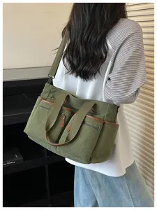 Casual groene corduroy tote tas met meerdere zakken en schouderriem voor dagelijks gebruik.