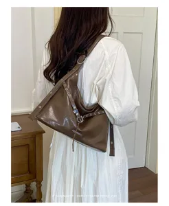 Stylish retro brown PU leather motorcycle shoulder bag with metal grommets for women.