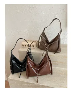 Retro PU leather motorcycle shoulder bag with metal grommets and strap detail, stylish dark design.