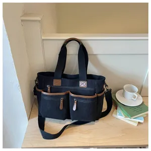 Gedetailleerd overzicht van de corduroy tote tas met vele zakken en leren afwerking.