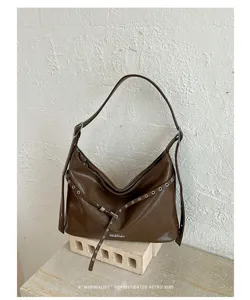 Detail view of brown PU leather hobo shoulder bag featuring stylish metal eyelets and strap.