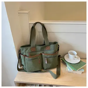 Detailopname van de groen corduroy tote bag met handig multi-pocket ontwerp en structuur.