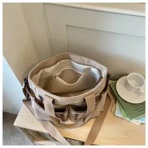 Gedetailleerd overzicht van de beige corduroy multi-pocket grote capaciteit tote tas.