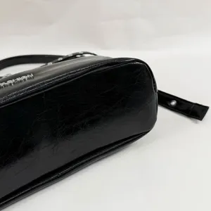 Close-up detail of the black glossy pu leather motorcycle shoulder bag strap and texture.