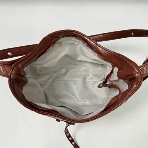Interior detail view of vintage PU leather motorcycle shoulder bag, showing lining and zipper.
