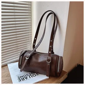 Detailansicht der vintage braunen zylindrischen Schultertasche mit Metallösen und doppelten Riemen.