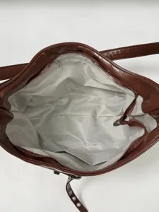 Brown PU leather shoulder bag for women, featuring zip pocket and stylish lining.