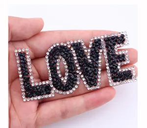 Gedetailleerde close-up van de sprankelende strass LOVE letter patch voor persoonlijke kleding.