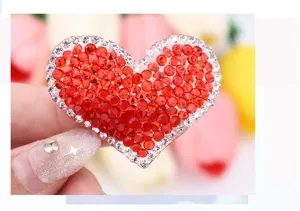 Gros plan détail de patch cœur en strass rouge, application de cristal étincelant vêtements.