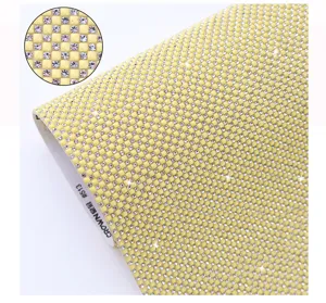 Detail view of yellow resin rhinestone mesh sheet with hot melt glue backing for DIY apparel decor.