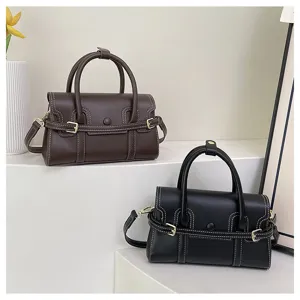 Gedetailleerd overzicht van trendy retro leren handtas met contrasterende stiksels.