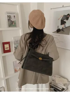Vista dettagliata della borsa tote vintage grigio scuro, con texture e chiusura metallica.