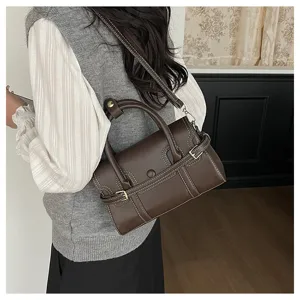 Detailopname van retro donkerbruine handtas met elegante stiksels en metalen gesp.