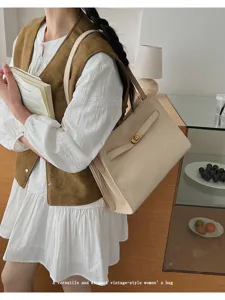 Vista dettagliata della borsa a tracolla beige elegante con dettagli dorati in ambiente chic.