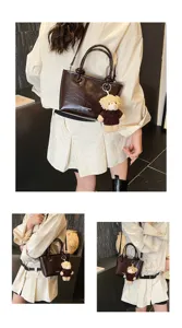 Womens dark brown leather handbag with cute bear pendant, stylish crossbody shoulder bag.