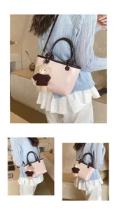 Detail view of the pink and brown handbag with cute teddy bear pendant and stylish knit top.
