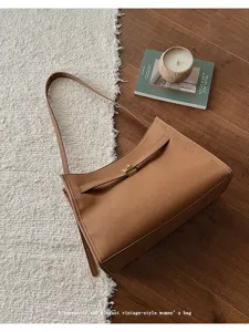 Dettaglio di borsa a spalla vintage da donna marrone con pelle di qualità e chiusura metallica chic.