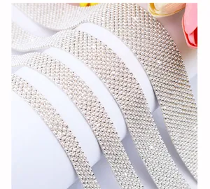 Detailopname van glinsterende parel-strassbanden en DIY-boorden voor kleding- en schoenendecor.