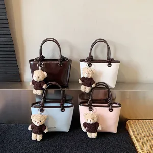 Stylish women tote bag with cute bear pendant, color block design, perfect daily shoulder bag.