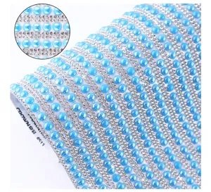 Close-up detail of self-adhesive rhinestone ribbon with blue pearls for DIY craft decoration.