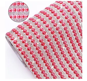 Detail shot of self-adhesive rhinestone ribbon with red beads and sparkling crystals for DIY crafts.