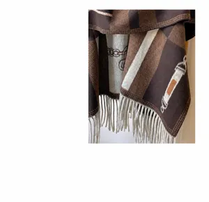 Vue détaillée du châle à franges à motif géométrique marron avec un design de boucle de chaîne.