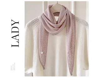 Nahaufnahme eines rosa gestrickten Dreieckschals mit Perle, elegantes Winter-Halstuch.