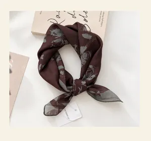 Detailansicht eines vintage dunkelbraunen Seidenquadrat-Tuchs mit eleganten grauen Schmetterlingen.