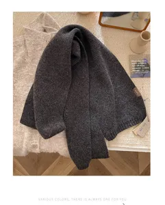 Close-up detail of the dark gray pure wool knitted scarf, soft texture and cozy winter styling.