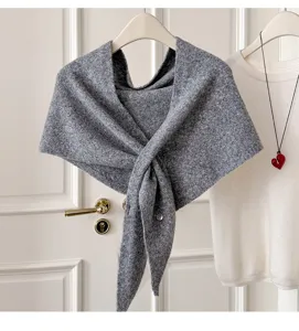 Nahaufnahme eines eleganten grauen Strick-Dreiecksschals mit Knotendesign für Damen.
