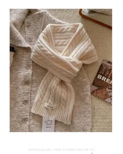Nahaufnahme des gemütlichen, beige gemusterten Wollschals mit weicher Textur und feiner Machart.
