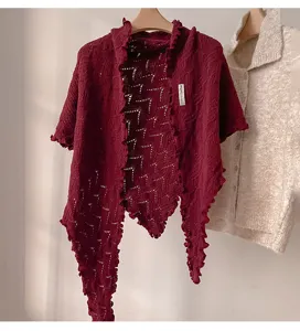 Detalle de chal asimétrico de punto rojo vino, borde ondulado retro mezcla de lana.