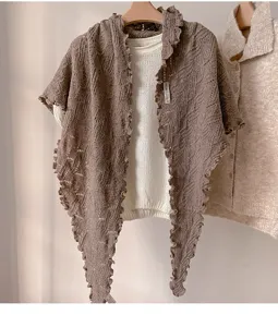 Cálido chal triangular de punto con borde ondulado, elegante prenda de otoño invierno.