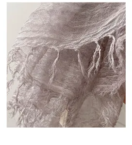 Detailaufnahme des eleganten helllila strukturierten Schals mit sehr zarten Fransen.
