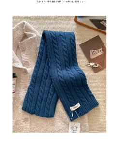 Nahaufnahme des dunkelblauen Zopfstrick-Wollschals mit feiner Textur und warmem Winterdesign.