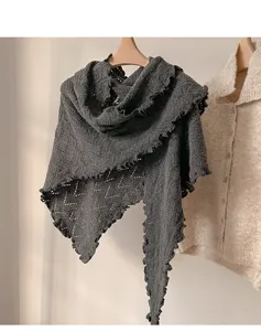 Detalle chal triangular de punto gris, borde ondulado elegante textura mezcla lana suave.