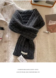 Nahaufnahme des dunkelgrauen grob gestrickten Wollschals mit weicher und warmer Wintertextur.