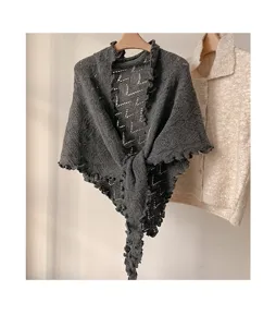 Chal triangular de punto gris oscuro con bordes ondulados, elegante cárdigan de lana retro.