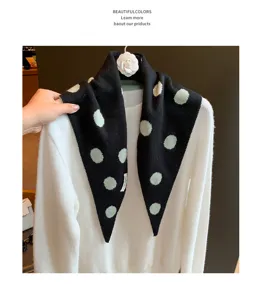 Vue rapprochée détaillée du foulard triangulaire en tricot à pois contrastés à la mode.