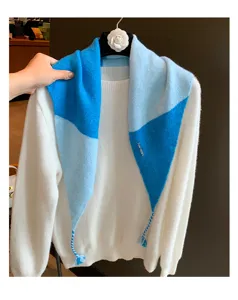 Detailansicht des stilvollen farbblockierten gestrickten Dreiecksschals und Pullovers.