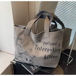 Casual canvas tote bag detail showing cute cat graphic design and daily commuting style.