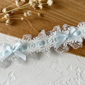 Detalle en primer plano de ribete de encaje con cinta azul claro y lazos para costura DIY.