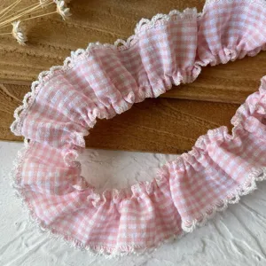 Primo piano dettagliato del bordo in pizzo vichy rosa con rifinitura picot per cucito fai-da-te.