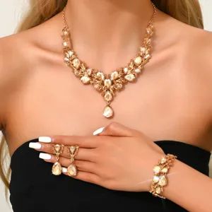 Primo piano del set di gioielli scintillanti color champagne con strass e gocce, collana e orecchini.