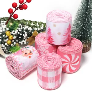 Rotoli di nastro natalizio rosa con babbo natale e fiocchi di neve per decorazioni e fai-da-te.