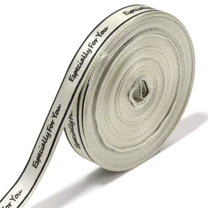 Gedetailleerde close-up van beige cadeaulint met fijne textuur en afgedrukte tekstdetails erop.