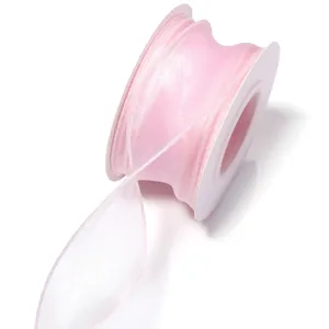 Pink organza ribbon roll close-up, sheer fish tail yarn fabric for gift wrapping and DIY crafts.