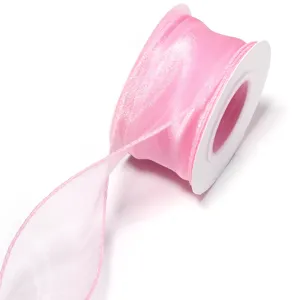 Pink organza ribbon roll detail shot for gift packaging and DIY crafts creation.