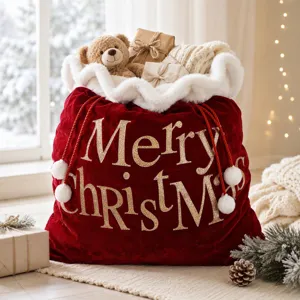 Détail du grand sac cadeau de Noël en velours rouge avec peluche d'ours et texte doré.