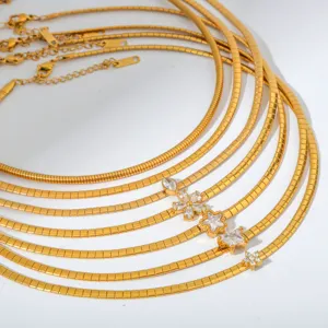 Detailansicht mehrlagiger goldfarbener Klingenketten mit funkelnden Zirkonia-Blumenanhängern.